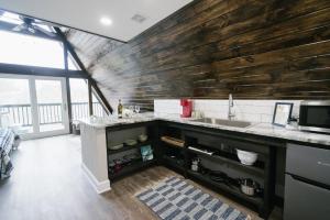 una cucina con lavandino e parete in legno di Dean's Den: Private Deck w/ Jacuzzi and a View a New Braunfels