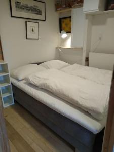 a bedroom with a bed with white sheets on it at Flat in the heart of Billund, 600m to Lego House, close to Legoland, Lalandia, Airport, in Billund