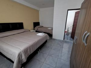 a hotel room with two beds and a mirror at El Depa de Saulo in Tarija