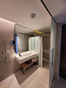 uma casa de banho com um lavatório e um espelho grande em Hotel Nacional Apart Lux no Rio de Janeiro