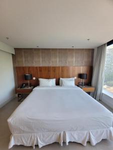 uma grande cama branca num quarto com 2 candeeiros em Hotel Nacional Apart Lux no Rio de Janeiro