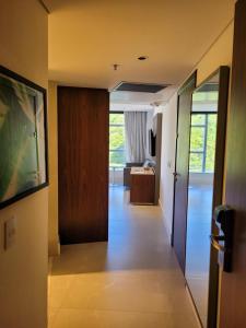 um corredor que leva a um quarto com uma porta e uma sala de estar em Hotel Nacional Apart Lux no Rio de Janeiro