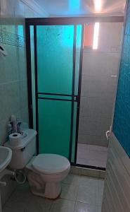 a bathroom with a toilet and a glass shower at Habitaciónes El Mirador in Cartagena de Indias