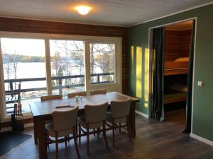 a dining room with a table and chairs and a large window at Ösjönäs in Tived