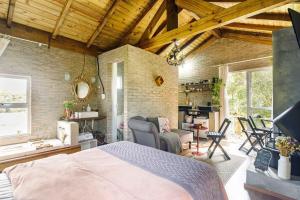 a bedroom with a bed and a brick wall at O Chalé Encantado - Rancho Queimado in Rancho Queimado