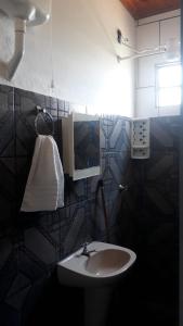 La salle de bains est pourvue d'un lavabo et d'une serviette. dans l'établissement POUSADA RECANTO DOS PASSAROS, à Pirenópolis