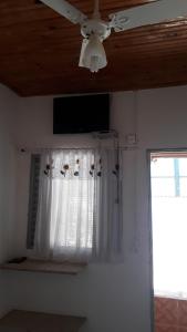 um ventilador de tecto e uma janela num quarto em POUSADA RECANTO DOS PASSAROS em Pirenópolis