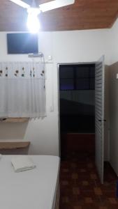 une cuisine avec des armoires blanches et une porte avec une fenêtre dans l'établissement POUSADA RECANTO DOS PASSAROS, à Pirenópolis