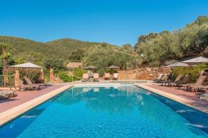 einen Pool mit Stühlen und Sonnenschirmen in einem Resort in der Unterkunft Logis Hôtel Restaurant Le Pradinas in Anduze