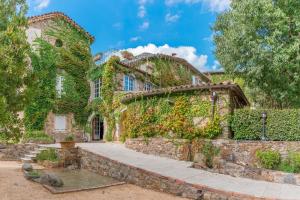 ein altes Steinhaus mit Efeu drauf in der Unterkunft Logis Hôtel Restaurant Le Pradinas in Anduze