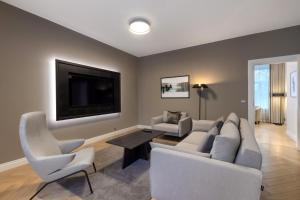uma sala de estar com um sofá e cadeiras e uma televisão em Nunne Boutique Hotel em Talin