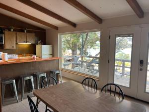 Tiny Cottage on Canyon Lake WATERFRONT في بحيرة كانيون: مطبخ مع طاولة وكراسي ونافذة كبيرة