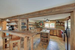 una cocina con armarios de madera y una gran mesa de madera. en The Lodge in Trout Creek Walk to Reservoir!, en Trout Creek