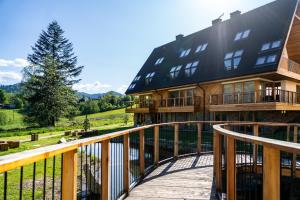 a large house with a deck and a balcony at Apartamenty Zana by Apart Concept Podhale in Kościelisko