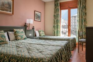 una camera d'albergo con due letti e una finestra di Hotel Sant Jordi by ALEGRIA ad Andorra la Vella