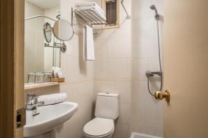 La salle de bains est pourvue de toilettes, d'un lavabo et d'un miroir. dans l'établissement Hotel Sant Jordi by ALEGRIA, à Andorre-la-Vieille