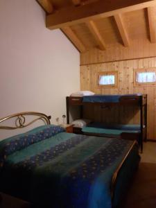 sypialnia z 2 łóżkami piętrowymi i 2 oknami w obiekcie Casa vacanze Emilio w mieście Temù