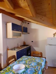 una pequeña cocina con mesa, mesa y sillas en Casa vacanze Emilio, en Temù