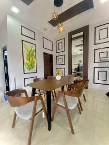 a dining room with a wooden table and chairs at Homestay Wakaf Bharu Tumpat in Wakaf Baharu