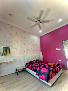 a bedroom with a bed and a pink wall at Homestay Wakaf Bharu Tumpat in Wakaf Baharu