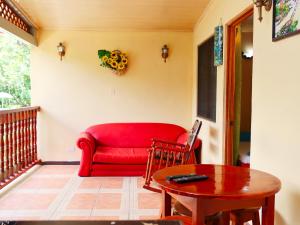 a living room with a red couch and a table at Villas Allen Puerto Viejo in Puerto Viejo