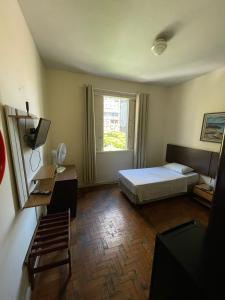 um quarto de hotel com uma cama e uma janela em Brasil Palace Hotel em Belo Horizonte