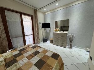a large bedroom with a bed and a television at Residenza butterfly IUN R6379 in Villasimius