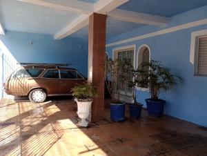a car parked in a room with potted plants at CASA de 2 QUARTOS in Guaratinguetá