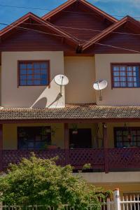 uma casa com duas antenas parabólicas no telhado em Hospedagem dona Tania em Canela