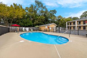 a swimming pool in a yard with a fence at Econo Lodge in Cheraw