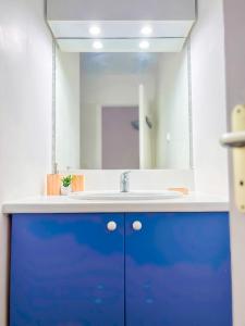 uma casa de banho com um lavatório azul e um espelho. em Magnifique Appartement Fleurs Caraïbes - 6 personnes en résidence avec piscine privée - Sainte Anne em Sainte-Anne