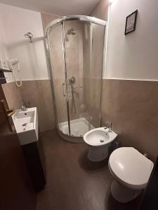a bathroom with a shower and a toilet and a sink at Conte House merulana guesthouse in Rome