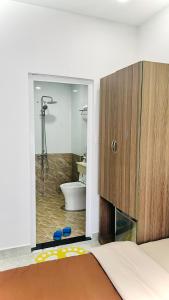 een badkamer met een douche, een toilet en een bed bij Uyên House hotel in Da Lat