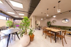 a restaurant with tables and chairs and potted plants at Doors Hotel in Tbilisi City