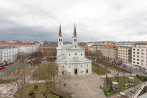 una gran iglesia blanca con dos torres en una ciudad en Private room connected to metro station and next to City center, en Viena