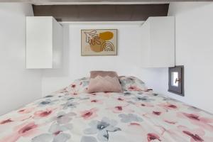 een slaapkamer met een bed met bloemen erop bij L'Effet Mer in Cap d'Agde