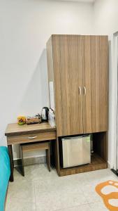 een houten kast naast een tafel met een magnetron bij Uyên House hotel in Da Lat