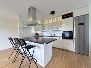 a kitchen with white cabinets and a black counter top at AD Long Stay Apartments in Stockholm