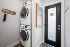 a laundry room with a washer and dryer next to a door at Stella Boona Loft Traverse close to Trail and beach in Traverse City