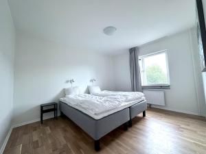 Cama en habitación blanca con ventana en AD Long Stay Apartments, en Estocolmo