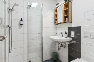 y baño con lavabo y ducha. en Vorstadtoase - Apartment für 2 Personen mit Smart TV, Parken, eigenen Bad, Netflix - Nähe BER, en Eichwalde