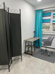 Cette chambre comprend un bureau, une chaise et une table. dans l'établissement Zimmer Türkis mit Weitblick und Sauna, à Sundern