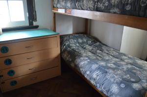 a small bedroom with a bunk bed and a dresser at Zeppelin Art-Hostel in Mar del Plata