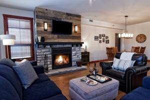 a living room with a couch and a fireplace at Tremblant Les Eaux A - Mont-Tremblant in Mont-Tremblant