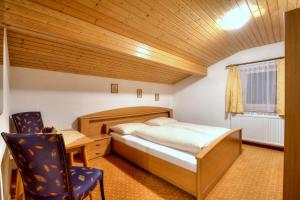1 dormitorio con cama, escritorio y silla en Ferienhaus Bergkristall, en Pettneu am Arlberg