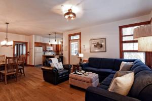 a living room with a blue couch and a table at Tremblant Les Eaux A - Mont-Tremblant in Mont-Tremblant