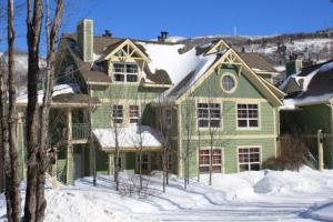 a green house with snow on the ground at Tremblant Les Eaux A - Mont-Tremblant in Mont-Tremblant