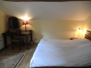 a bedroom with a white bed and a desk with a chair at Bakhuisje 6p nabij Durbuy in Villers-Sainte-Gertrude