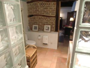 a bathroom with a toilet and a brick wall at Bakhuisje 6p nabij Durbuy in Villers-Sainte-Gertrude
