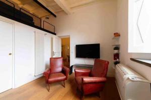 sala de estar con 2 sillas y TV de pantalla plana en Casa Cecilia Roma en Roma